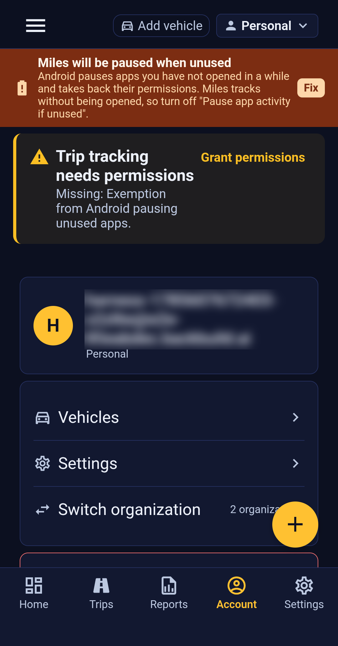 The Account tab in Backbuild Miles. An identity card shows an avatar initial, the signed-in email address (redacted in this screenshot) and the current organization, which reads Personal. Below the card are rows for Vehicles, Settings, and Switch organization annotated 2 organizations, then a Sign out action. Two warning banners sit above the card: Miles will be paused when unused, and Trip tracking needs permissions naming a missing exemption.